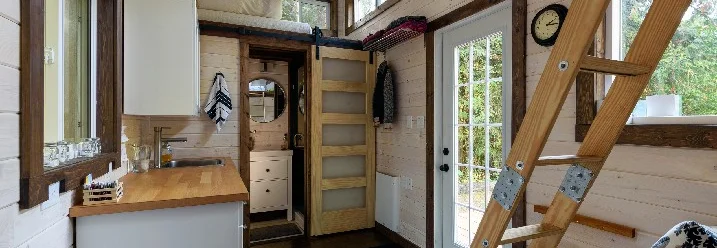 Innenraum eines Tiny House mit Holzleiter
